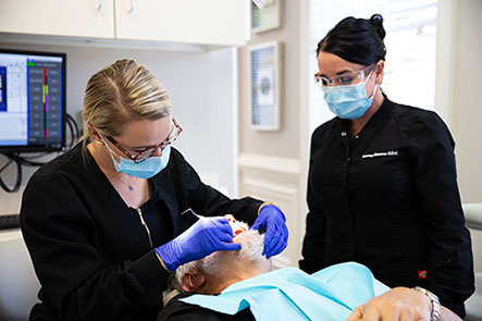 Doctor performs a restorative dentistry procedure on a patient at Reich Dental Center.