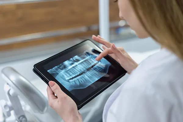 Dentist reviews a patient's digital xrays on her tablet device
