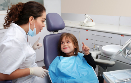 Young girl in dental chair smiling at Reich Dental Center – Roswell